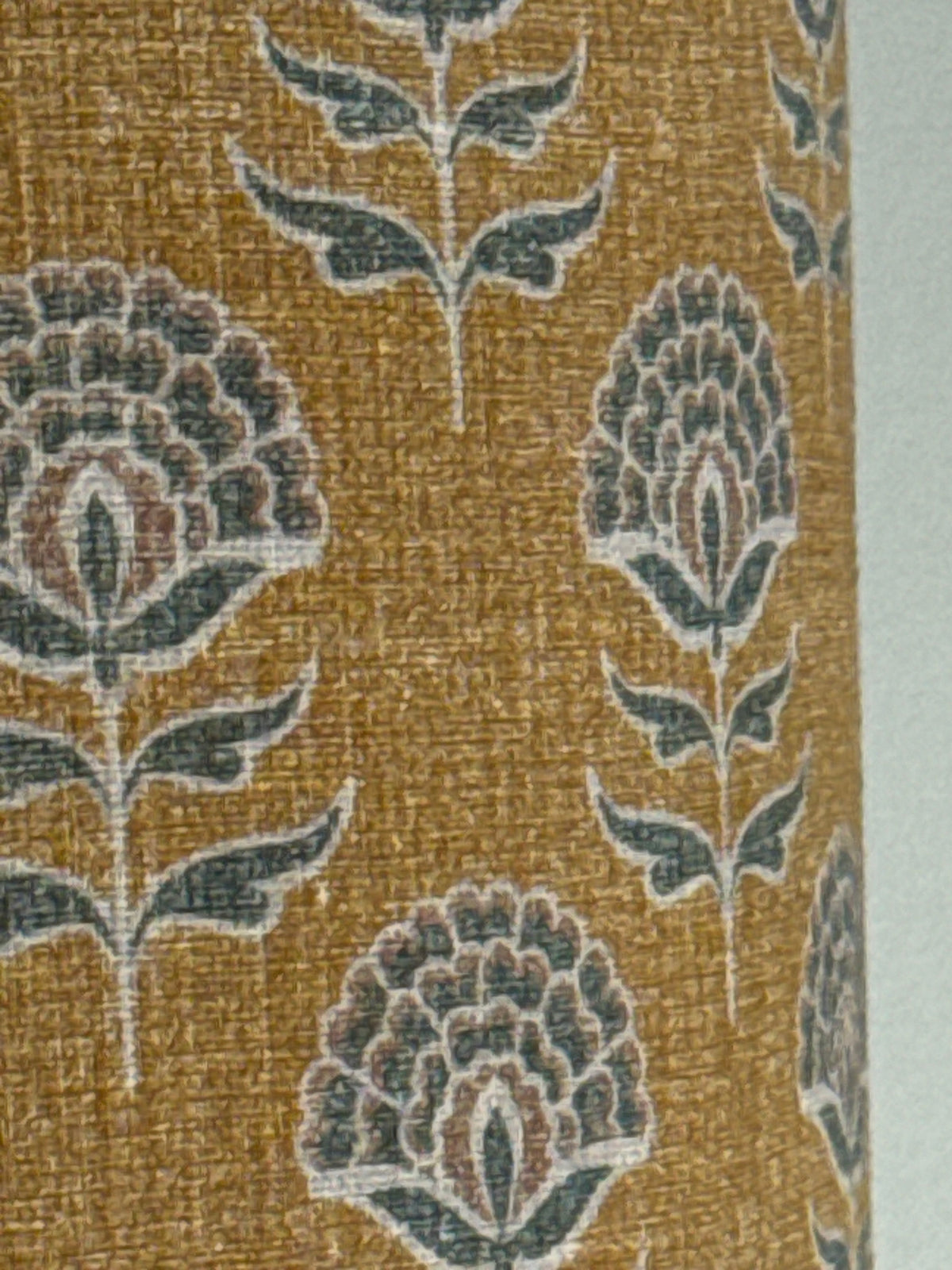 Close-up of a textured fabric with floral patterns on a gold background