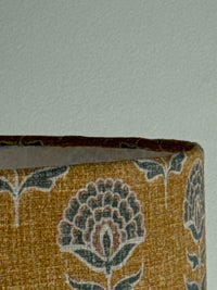Close-up of a patterned fabric roll with floral design on a light gray background