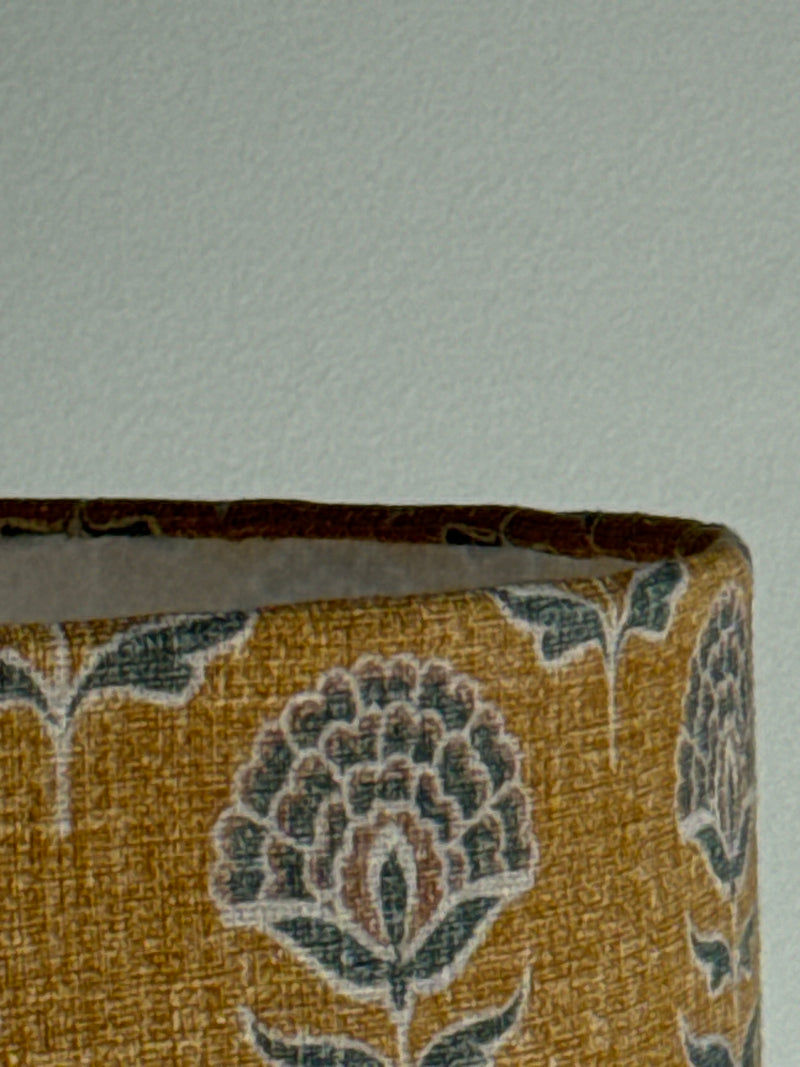 Close-up of a patterned fabric roll with floral design on a light gray background
