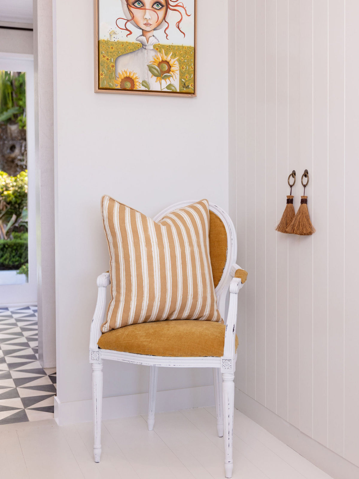 Chair with striped cushion in a room with a framed picture on the wall.