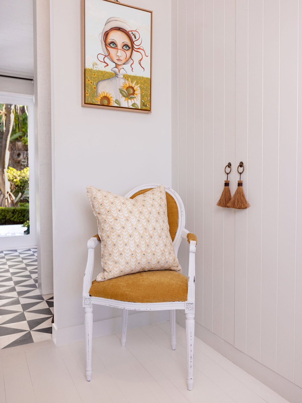 Chair with a cushion and a framed picture on a white wall