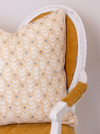 Patterned pillow on a mustard yellow chair with white frame
