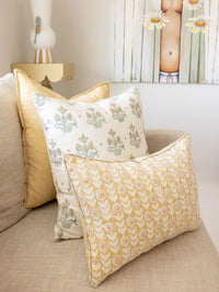 Decorative pillows with floral patterns on a beige sofa.