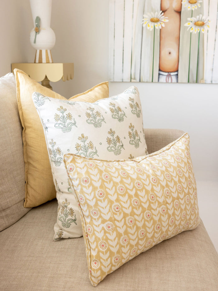 Decorative pillows with floral patterns on a beige sofa.