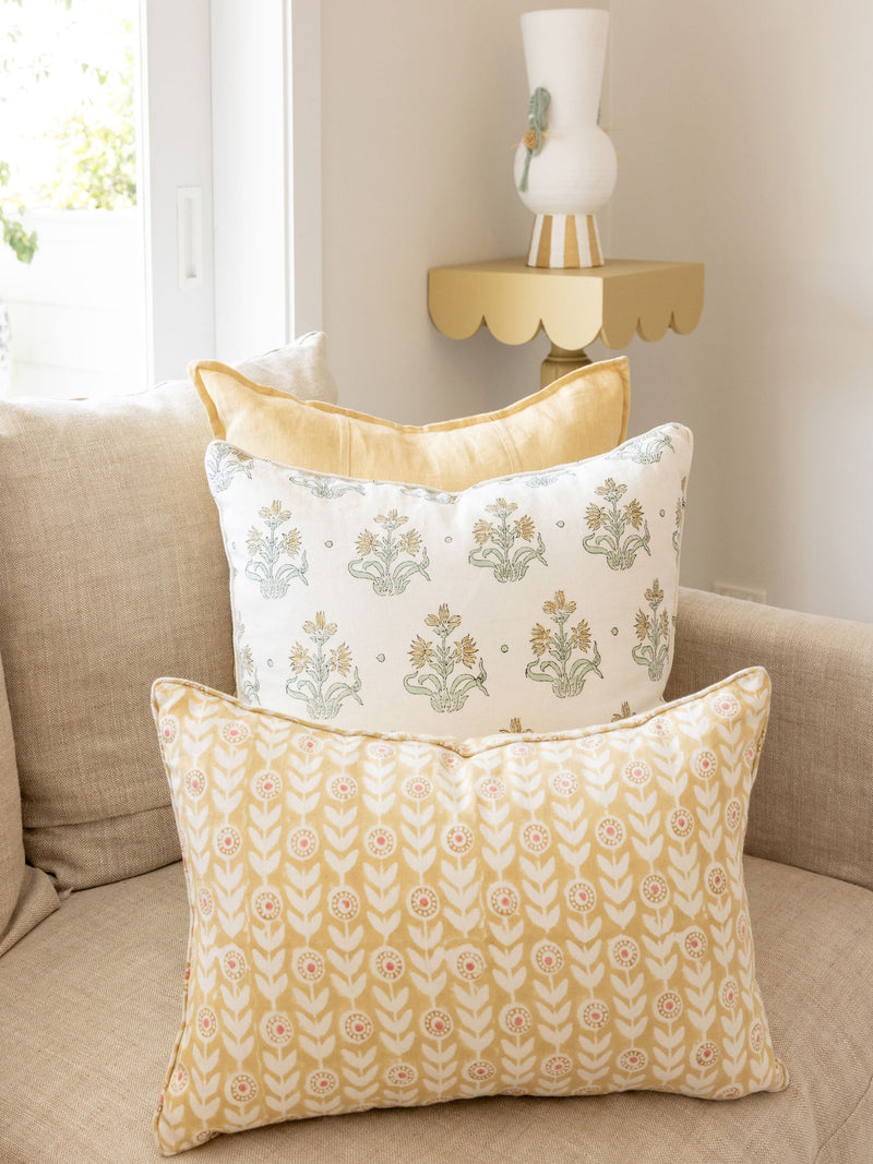 Decorative pillows on a couch with a side table in the background
