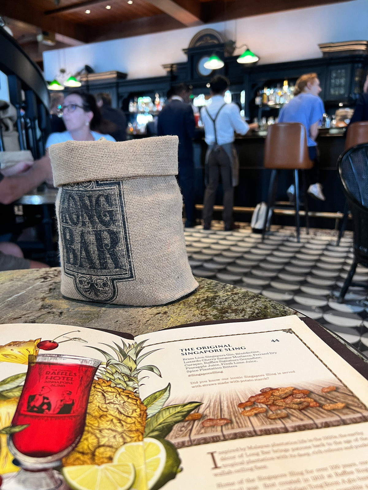 Bar setting with a towel and menu featuring a pineapple and red drink.