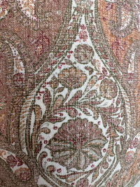 Close-up of intricate paisley pattern on fabric with earthy tones.