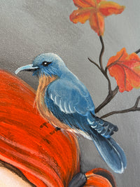 Painting of a blue bird on an orange leaf with autumn leaves in the background