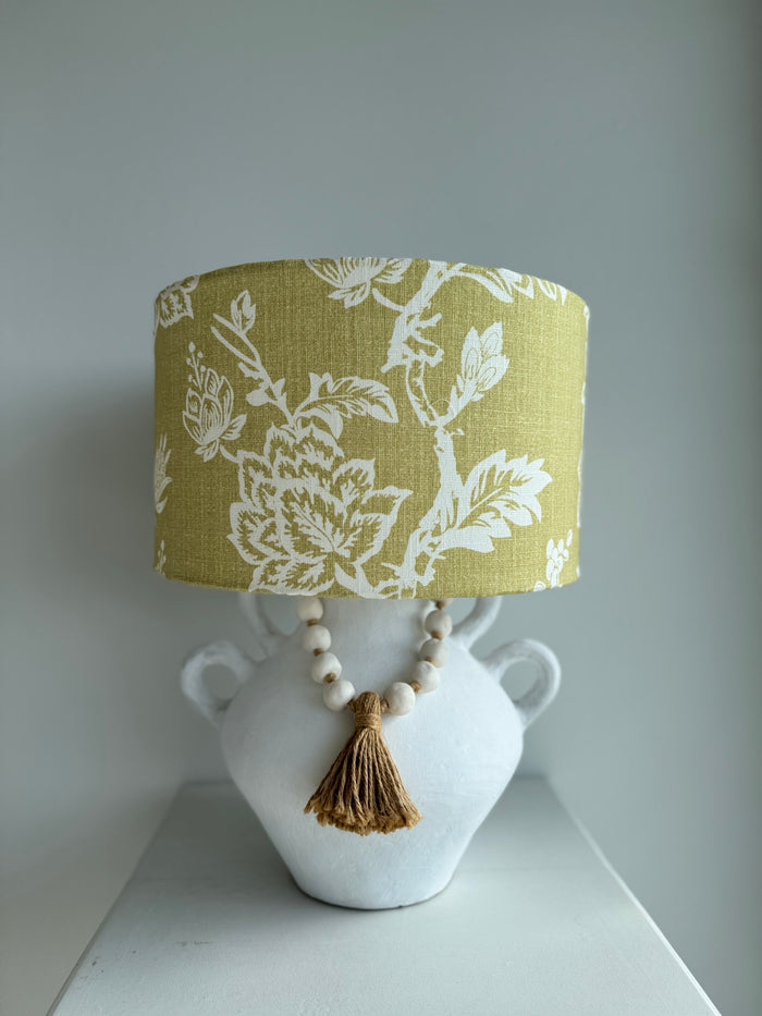 Lamp with a floral-patterned shade on a white base against a gray background