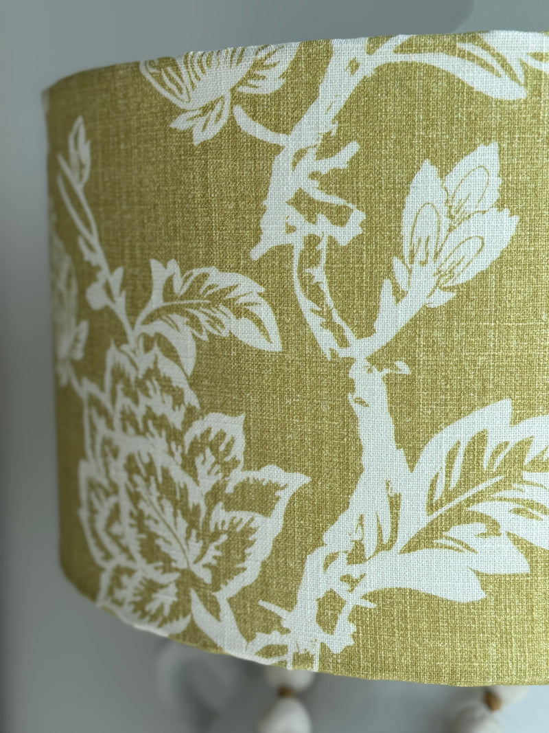 Fabric lampshade with white floral pattern on a green background