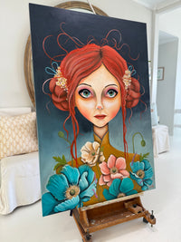 Painting of a woman with red hair and flowers on an easel in a room.