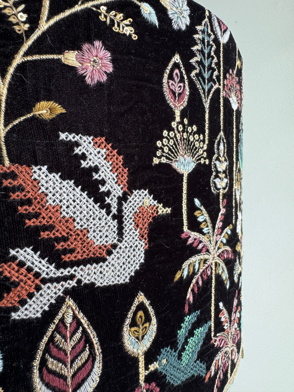 Embroidered fabric with a phoenix design and floral elements on a black background
