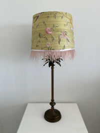 Lamp with a floral patterned shade on a white surface and light gray background