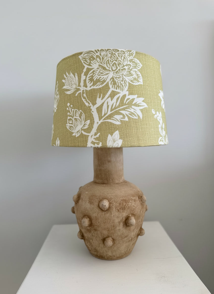 Lamp with a floral-patterned shade on a neutral background