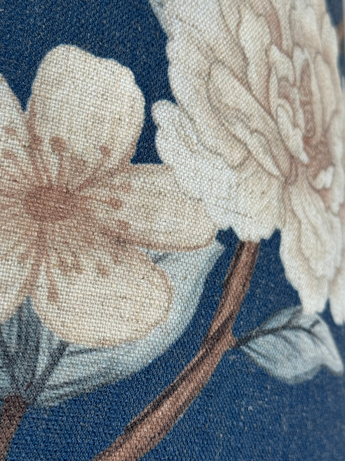 Close-up of floral embroidery on fabric with a blue background