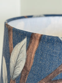 Close-up of a cylindrical container with leaf pattern on a blue background