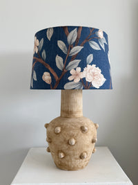 Lamp with a decorative blue floral lampshade on a neutral background