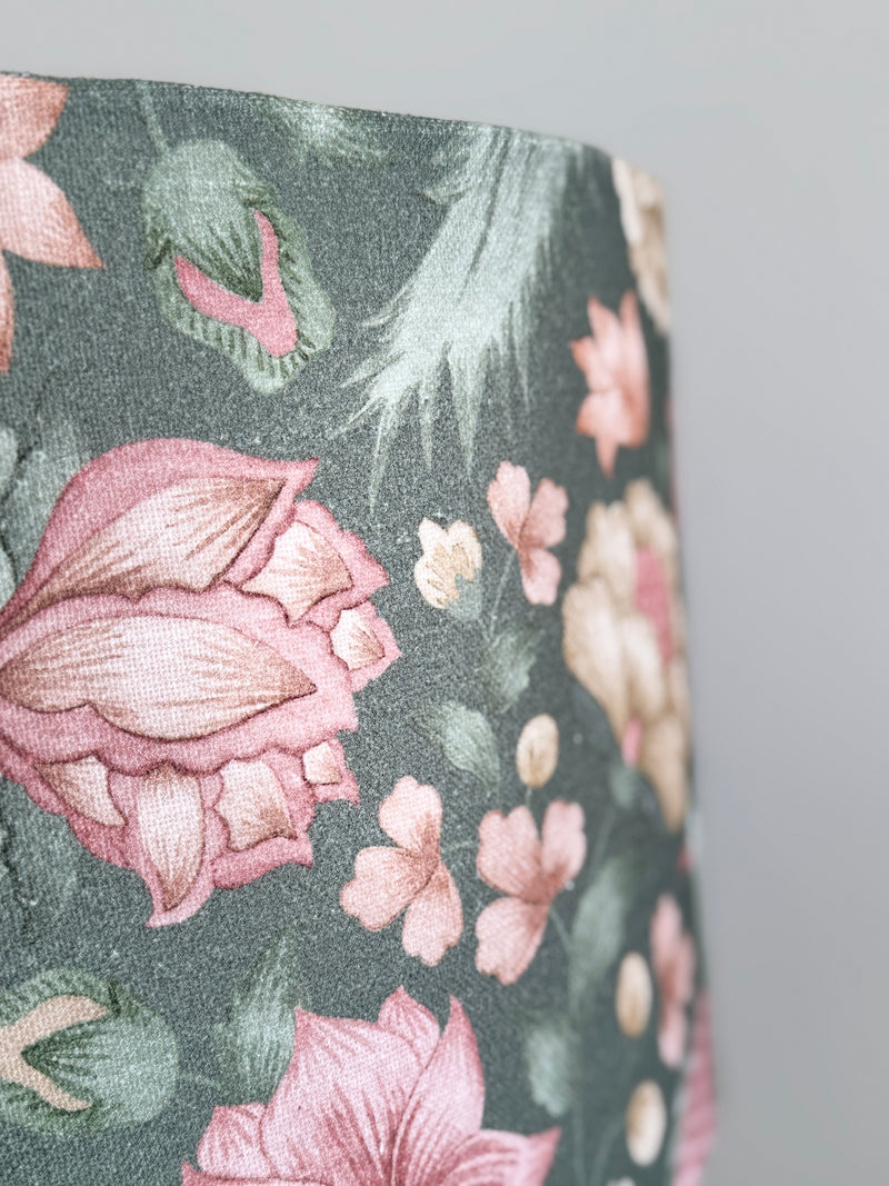 Floral patterned fabric with pink flowers and green leaves on a dark background