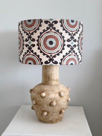 Decorative lamp with a patterned shade on a plain background