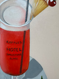 Raffles Hotel Singapore Sling bottle with cocktail ingredients on a tablecloth