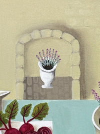 Framed artwork of a table setting with food on a wall above a woven basket with 'BREAD' text.
