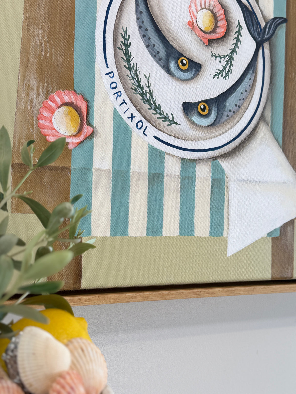Decorative wall art with fish and shell design on a striped background
