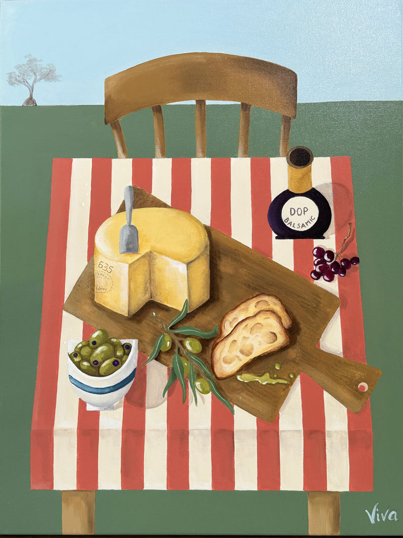Framed artwork of a still life scene with cheese, bread, and olives on a striped tablecloth.