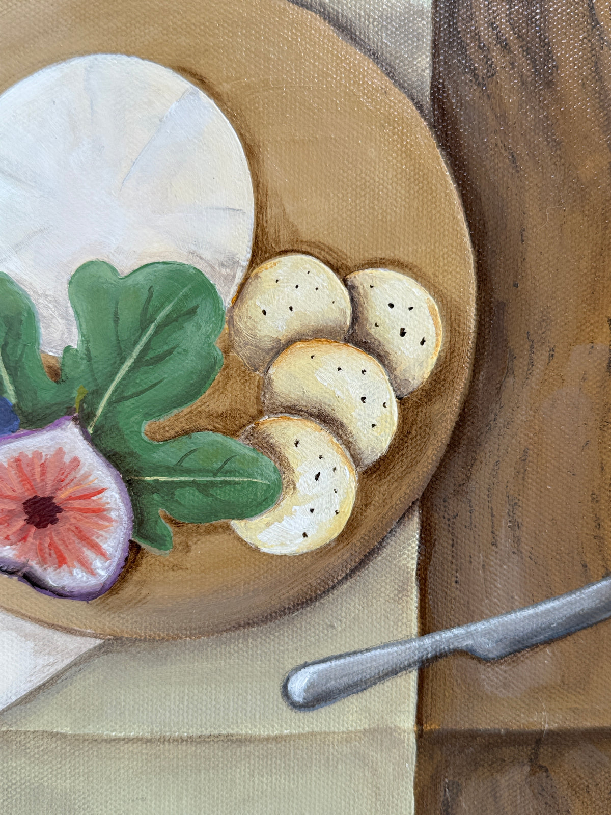 Wooden plate with figs, cheese, and crackers on a wooden table.