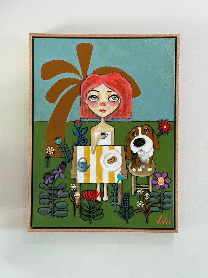 Framed artwork of a woman with red hair and a dog in a garden setting.