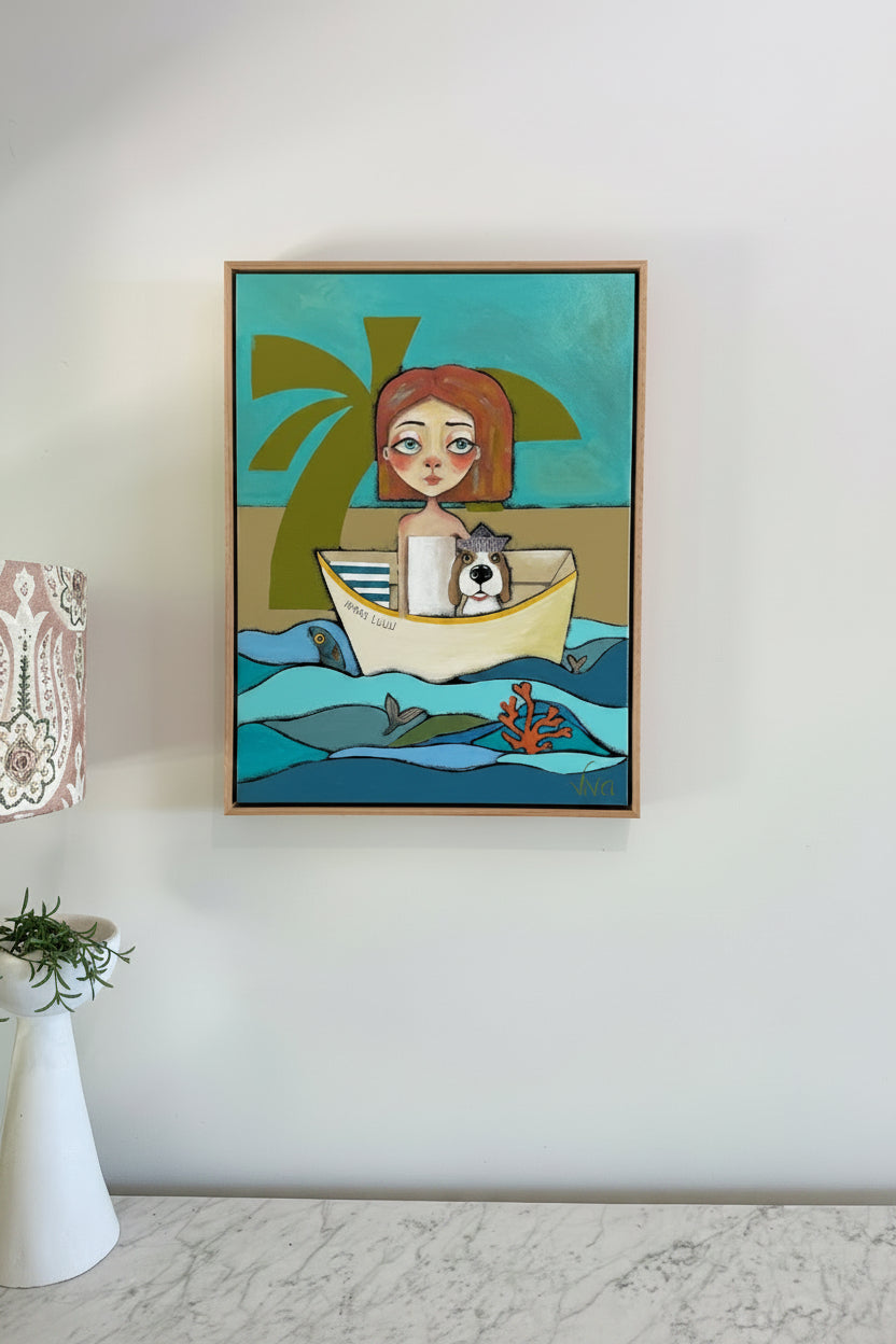 Framed artwork of a woman with a dog in a boat on a beach scene, hanging on a white wall.