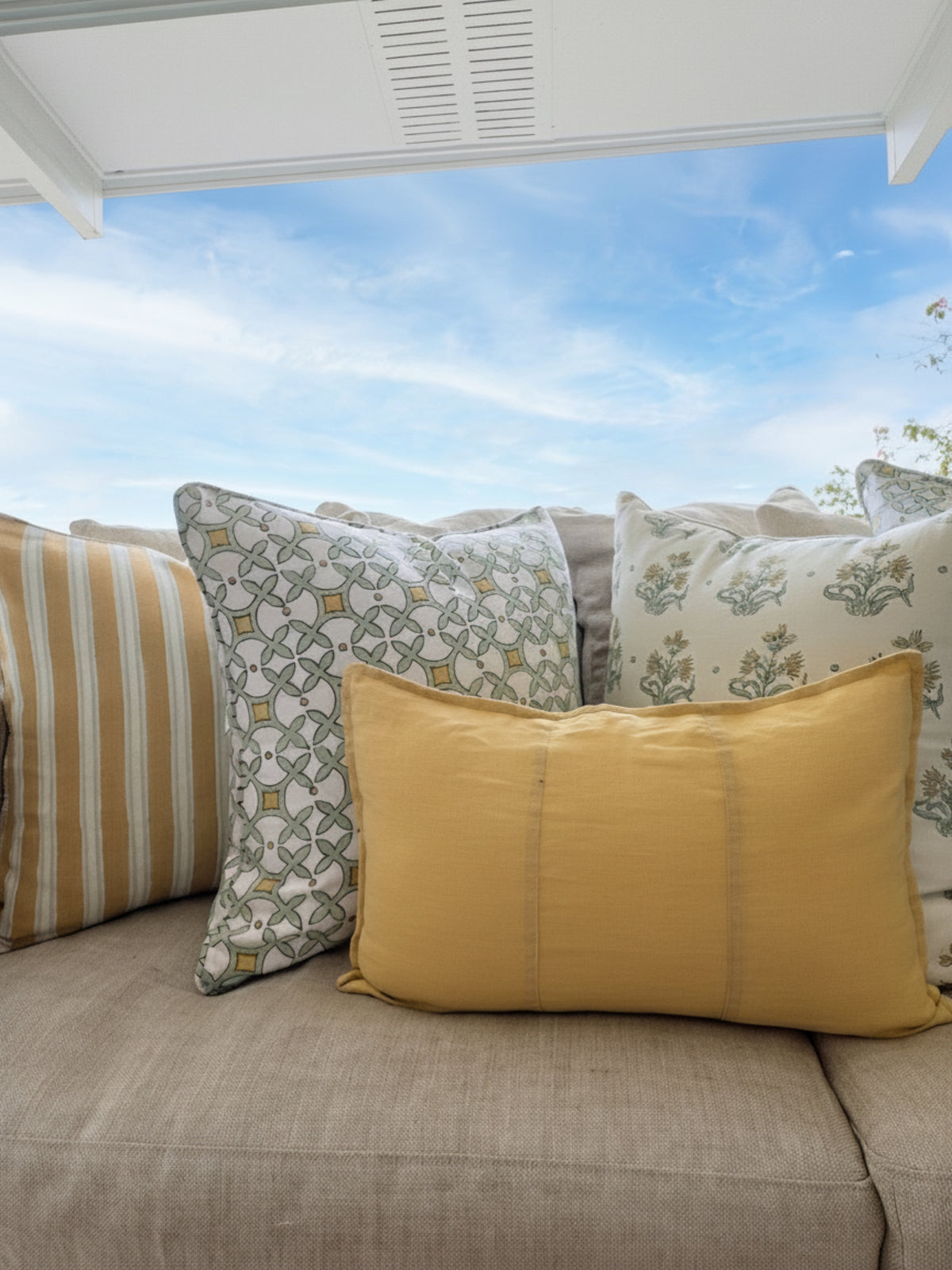 Sofa with decorative pillows by a window with white frame