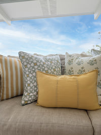 Sofa with decorative pillows by a window with white frame