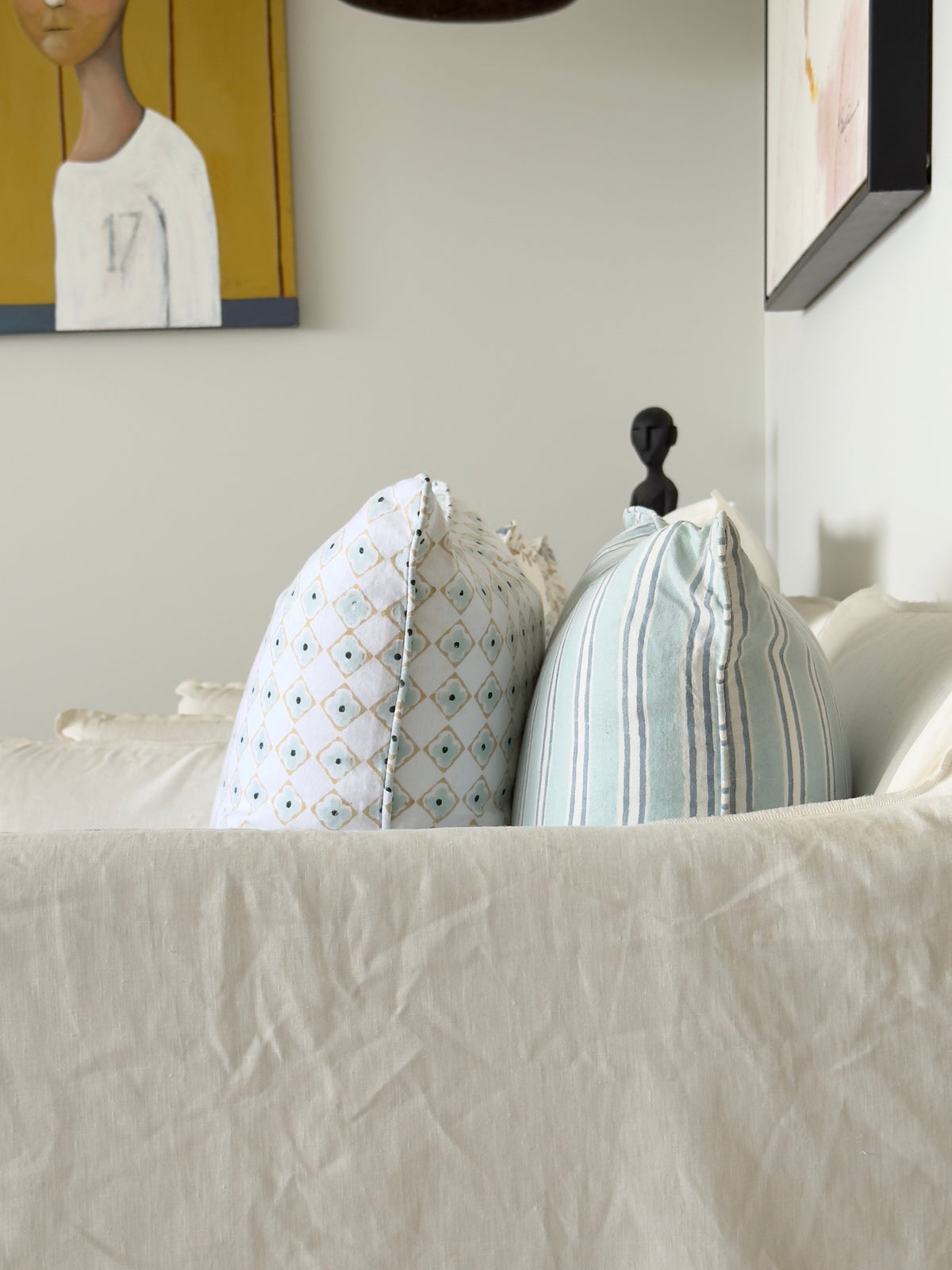 Close-up of a bed with pillows and a mattress corner, showing bedding details.