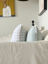 Close-up of a bed with pillows and a mattress corner, showing bedding details.