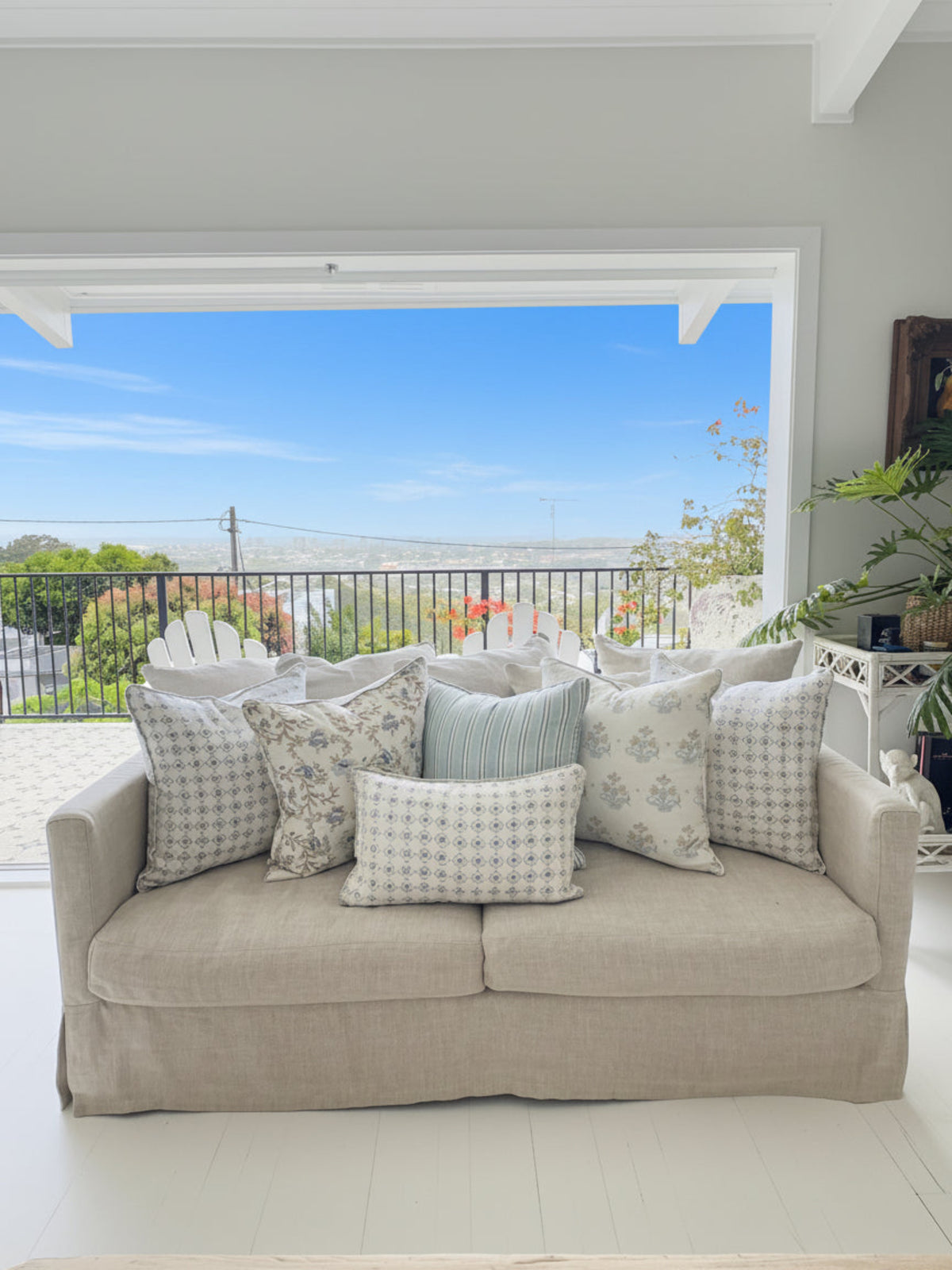 Beige sofa with patterned cushions in a room with a door leading outside.