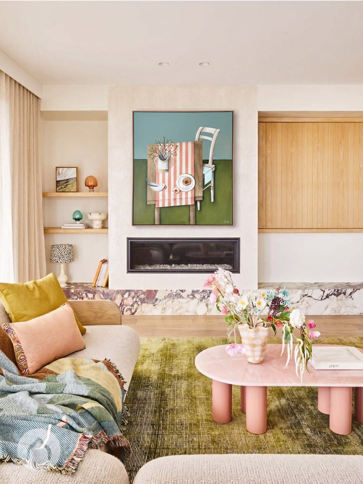 Modern living room with a pink coffee table, colorful rug, and wall art.